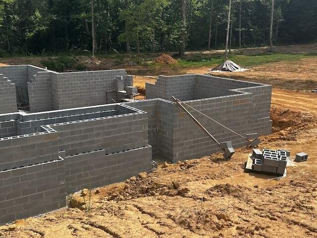 “custom home foundation being laid with concrete blocks in an unfinished building site”