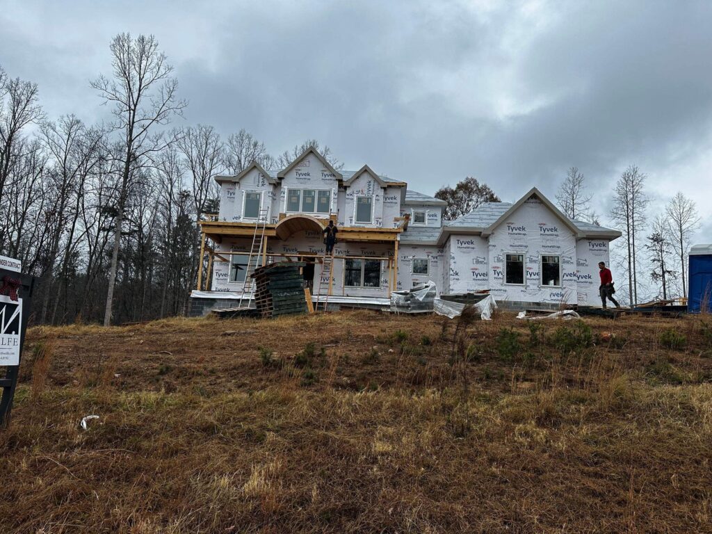 construction of a custom home with exterior framing and weatherproofing materials applied on the walls and roof areas