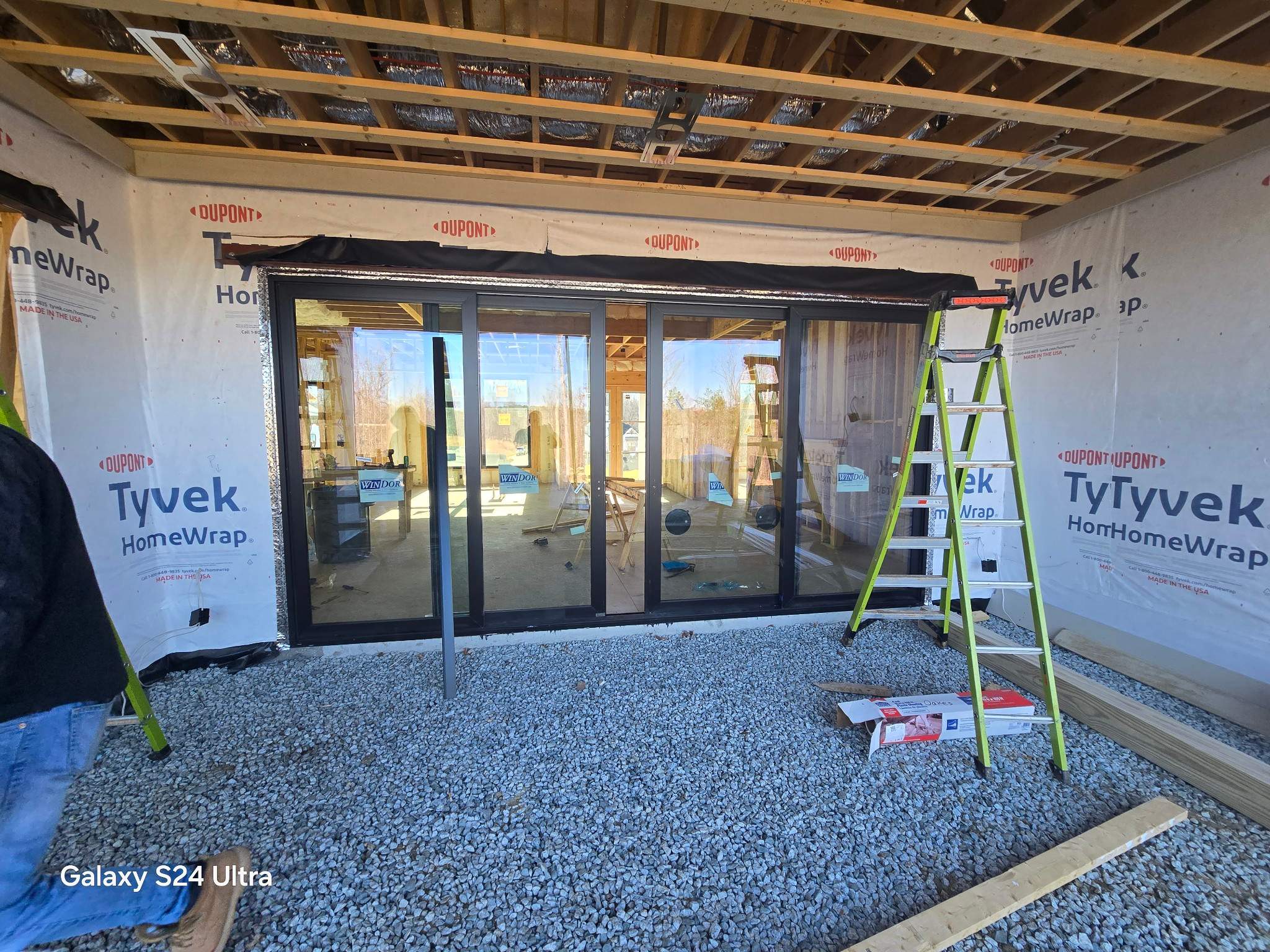 this image shows construction progress with a focus on exterior walls and window installation using tyvek homewrap for insulation